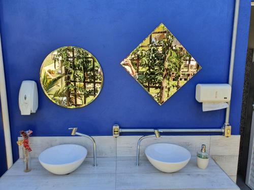 戈亚斯州上帕莱索João de Barro camping e suítes的浴室设有两个水槽和两面墙上的镜子