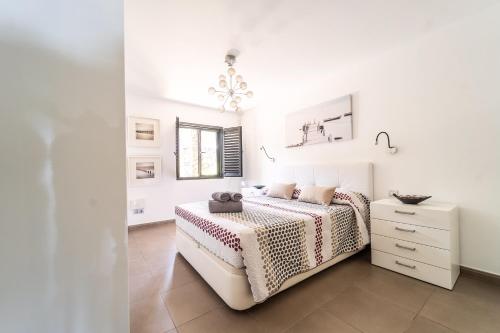 阿吉拉海滩Casa Martín.的一间白色卧室,配有一张床和一个梳妆台