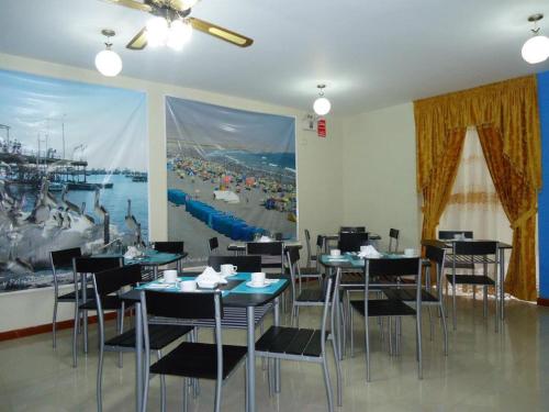 伊洛Hostal Puerto Ingles的一间带桌椅的用餐室和一幅大画