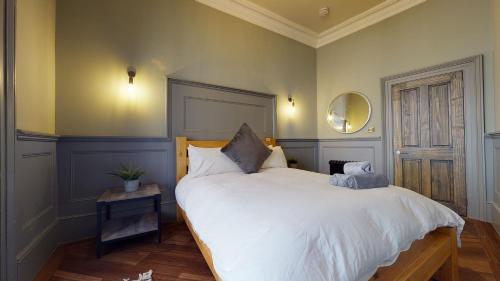 普里茅斯Barbican Boutique Luxury Apartments & Rooms, Plymouth的卧室配有一张白色大床和镜子