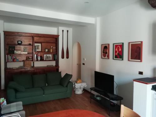 博洛尼亚La casa di Sacco - Appartamento Bologna Centro的客厅配有绿色沙发和电视