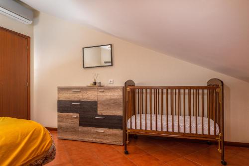 卡列塔CASA POR DO SOL的一间卧室配有婴儿床和带镜子的梳妆台