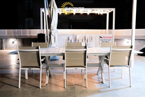 埃拉特Sun Center Eilat的餐厅内的白色餐桌和椅子
