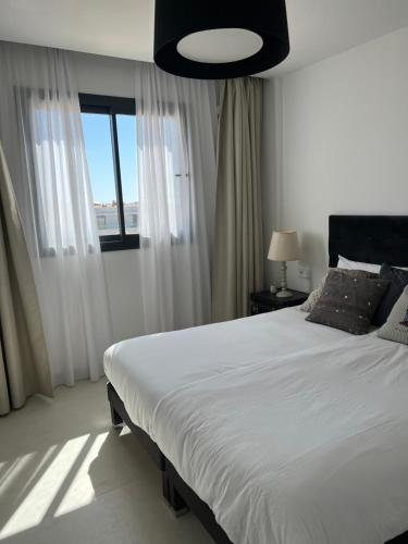 福恩吉罗拉New apartment in Higueron West的卧室设有一张白色大床和一扇窗户。