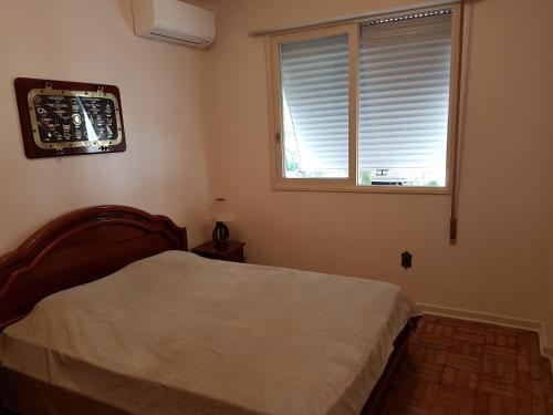 桑托斯Apartamento em frente a Praia do Embaré - Santos的一间卧室设有一张床和一个窗口