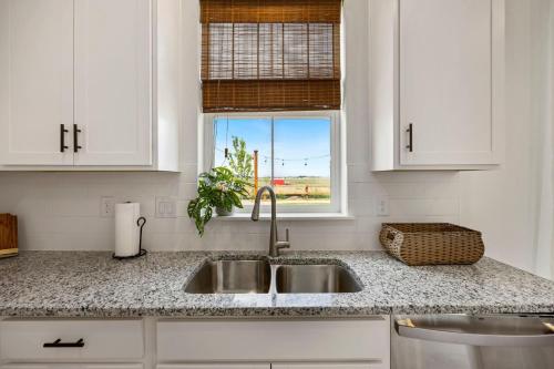 拉夫兰Spacious Home, Great Backyard with Mtn Sunset Views!的白色的厨房设有水槽和窗户