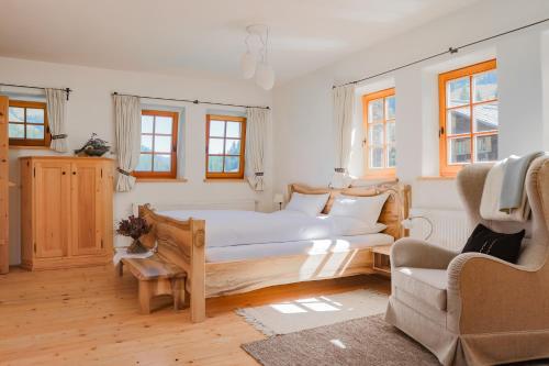 莱赫阿尔贝格Appartement Graf的一间卧室配有一张大床和一把椅子