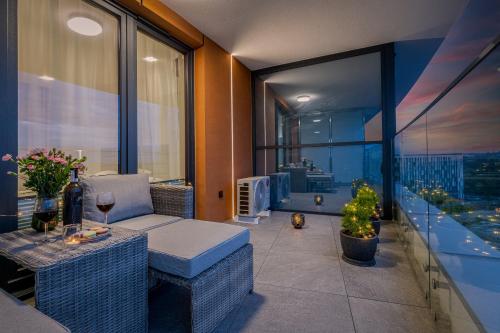 克拉科夫马修宾馆公寓的阳台配有沙发和一张带葡萄酒玻璃的桌子。