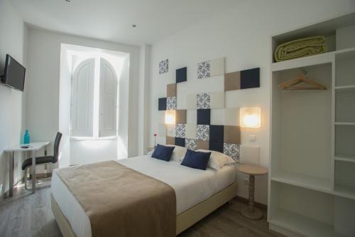 托马尔托玛尔故事旅馆的一间卧室配有一张床、一张桌子和一个窗户。