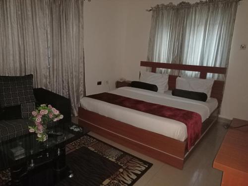 阿布贾Villa Nuee Hotel & Suites Utako, Abuja的一间卧室配有一张大床和一张沙发