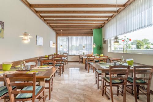 萨尔茨吉特巴德Hotel Kniestedter Hof的用餐室配有木桌和椅子