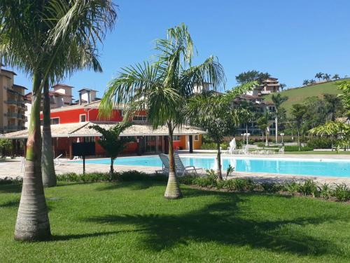 卡拉瓜塔图巴Apartamento a 50m da areia - Praia da Tabatinga的一个带游泳池和棕榈树的度假村
