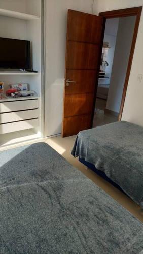 亚松森Hermoso conjunto residencial con piscina的一间卧室配有一张床和一个衣柜及一台电视