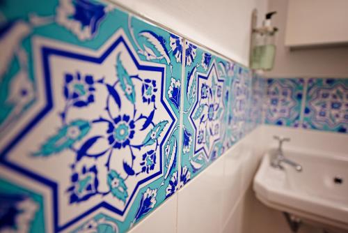 爱丁堡Cosy one bedroom flat in city center的浴室的墙壁上铺有蓝色和白色的瓷砖。