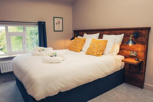 康格尔顿Reubens Congleton的卧室配有带橙色枕头的大型白色床