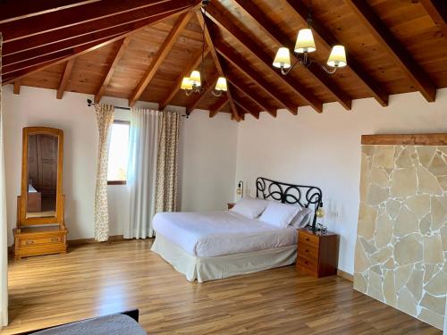 伊科德洛斯维诺斯Las Villas de Gardel的卧室配有白色的床,铺有木地板