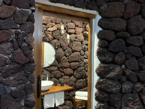 伊科德洛斯维诺斯Las Villas de Gardel的浴室设有石墙、水槽和镜子