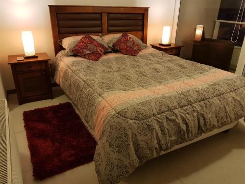 拉塞雷纳DEPARTAMENTO EN RESORT LAGUNA DEL MAR的一间卧室配有一张带2个床头柜和2盏灯的床。