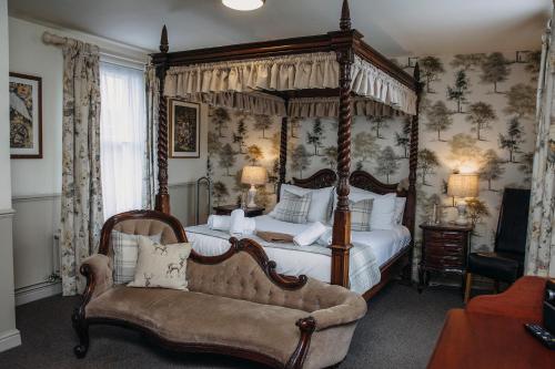沃明斯特乔治旅店 的一间卧室配有四柱床和沙发