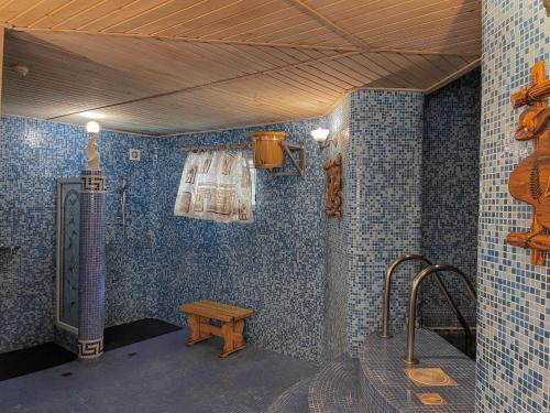 博罗沃耶Hotel Gloria Standard的浴室设有蓝色瓷砖墙壁和长凳