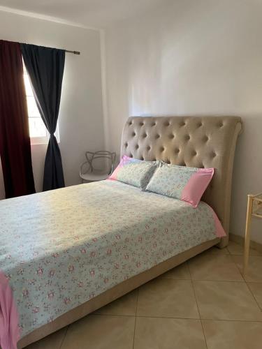 普拉亚Apartamentos Avenida的一间卧室配有带粉红色和蓝色枕头的床