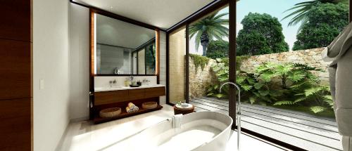 CihuatlánFour Seasons Resort Tamarindo, México的带浴缸的浴室和大窗户