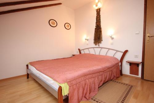 科米扎Apartments by the sea Komiza, Vis - 8533的一间卧室配有一张床,墙上挂着两个钟。