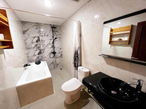 八丹拜Bali 85 Beach Inn的浴室配有盥洗盆、卫生间和浴缸。