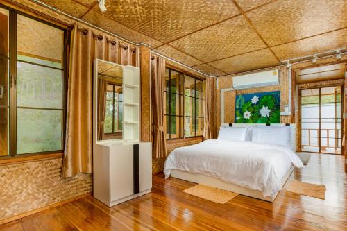 Ban Huai SaiHin Khong Villa - a tropical surprise的一间卧室设有一张床和一些窗户。