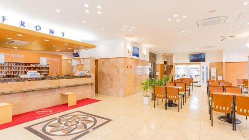 神户Toyoko Inn Kobe Sannomiya No 1的一间带桌椅和柜台的餐厅