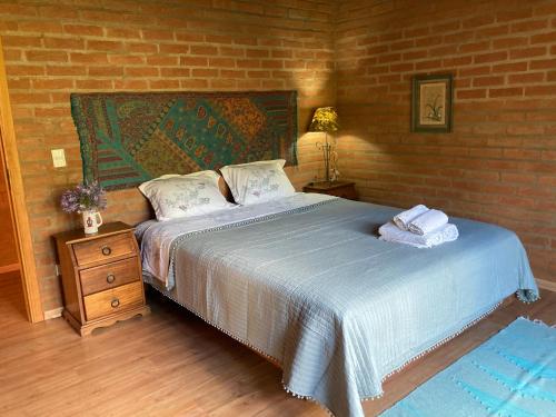 圣本图-杜萨普卡伊Casa Baúau的一间卧室设有一张床和砖墙