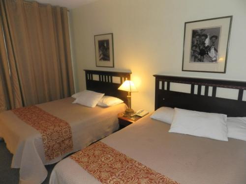多瓦尔奥伯格机场酒店的酒店客房,设有两张床和一盏灯
