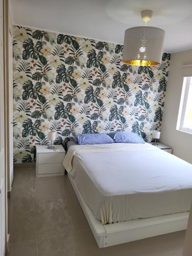 曼塔New 3 bedroom home in modern housing complex的一间卧室配有一张带花卉壁纸的床
