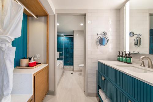 塔穆宁关岛皇冠假日度假酒店的一间带水槽和蓝色橱柜的浴室