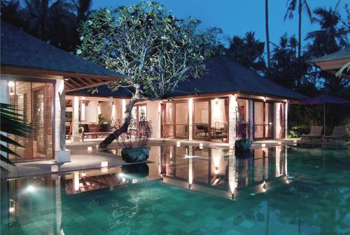 金巴兰JEstate villas & guest houses - Jimbaran的夜间带游泳池的别墅