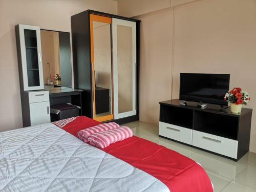 芭堤雅市中心OYO 75414 KJS Pattaya​的一间卧室配有一张床和一台平面电视