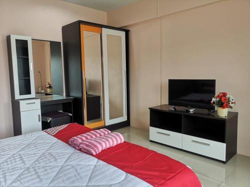 芭堤雅市中心OYO 75414 KJS Pattaya​的一间卧室配有一张床和一台平面电视