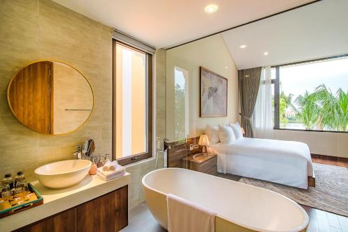 会安Hoi An Memories Resort & Spa的带浴缸、床和盥洗盆的浴室