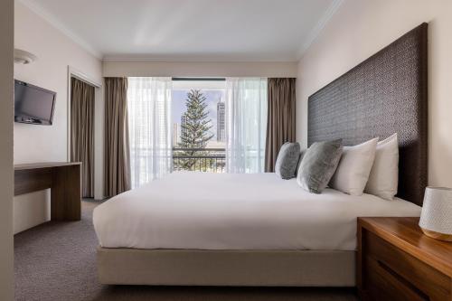 黄金海岸满特拉皇冠塔酒店的一间设有大床和窗户的酒店客房