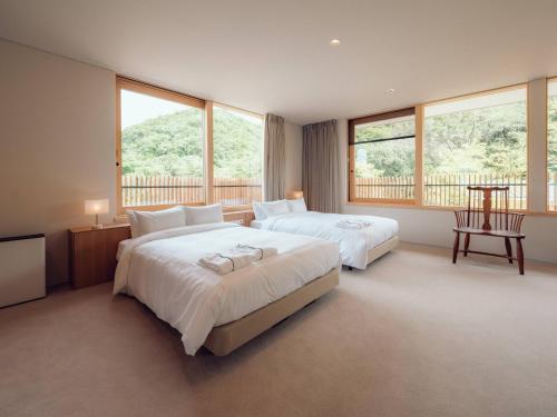 Hatago Vison的一间大型卧室,配有两张床和窗户