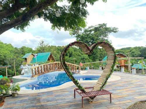 纳苏格布Don Roberto's Kubo Resort的坐在泳池旁的长凳上的心雕