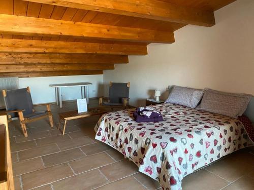 索尔索Alloggio con piscina a Sorso 3 kilometri dal mare的卧室配有一张床和一张桌子及椅子