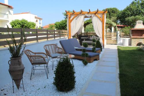 尼基季Azure Bliss Suites的后院的庭院配有蓝色的沙发和椅子