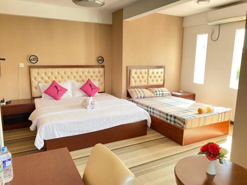 DivulapitiyaSundale Hotel的酒店的客房 - 带2张带粉红色枕头的床