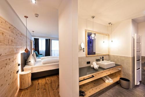 雷西亚Hotel Zum Mohren的一间卧室配有床、水槽和镜子