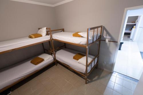 维多利亚Hostel Diniz的带三张双层床和镜子的客房