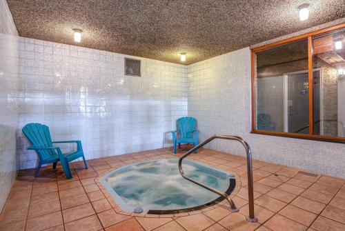 弗农弗农戴斯酒店的一个带两把蓝色椅子的房间的热水浴缸