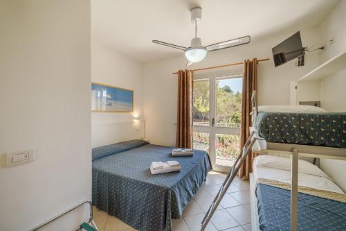 阿祖罗港旺达别墅酒店的一间卧室设有两张双层床和一扇窗户。