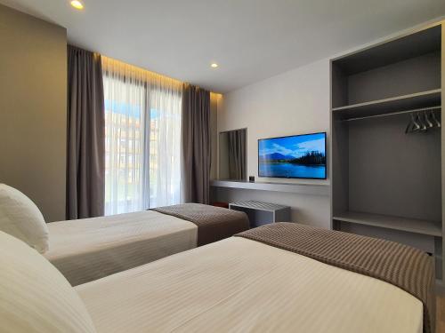 萨兰达LOOKOUT Apartments的酒店客房设有两张床和一台平面电视。