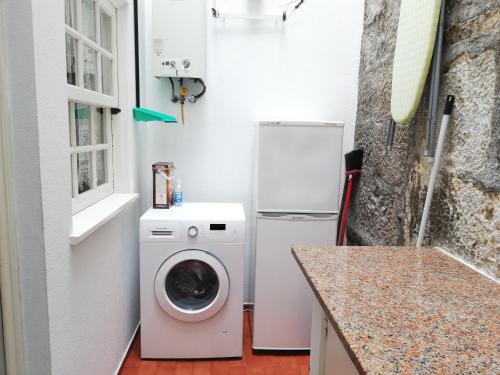 维亚纳堡Alojamento Local Ferros - Duplex的厨房配有洗衣机和冰箱。